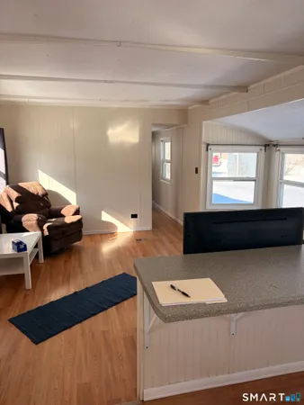 a living room with a table chairs and a wooden floor