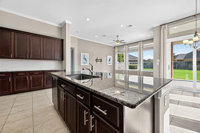 a kitchen with granite countertop a sink and a stove