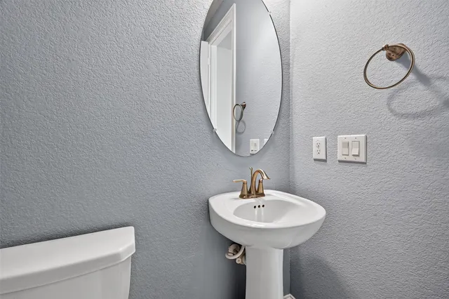 a kitchen with granite countertop a refrigerator a sink and white cabinets