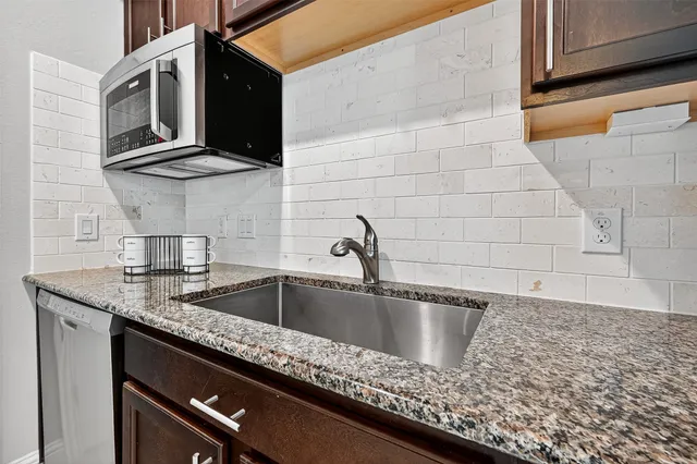 a kitchen with granite countertop a sink and cabinets