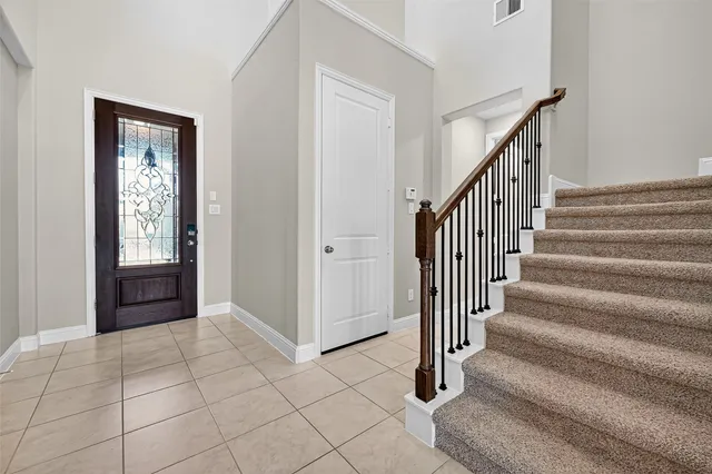 a view of a hallway with entryway and stairs