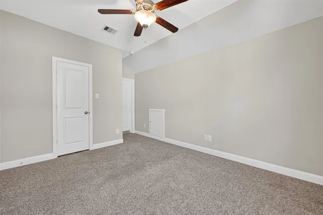 an empty room with a window and a fan