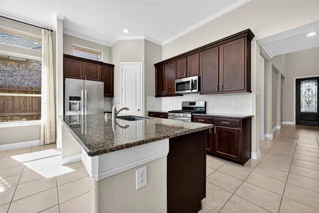 a kitchen with stainless steel appliances granite countertop a stove a sink and a microwave
