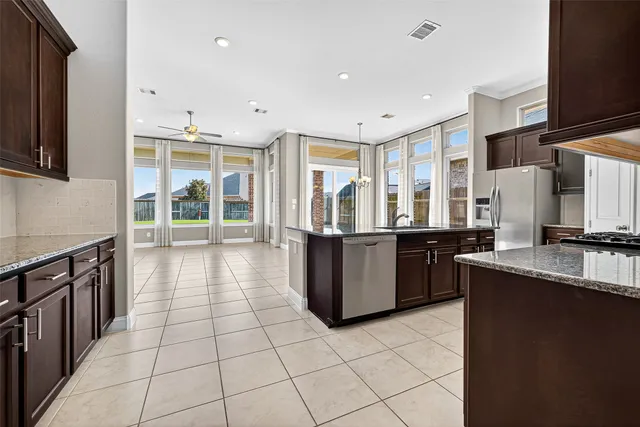 a large kitchen with a large counter top and stainless steel appliances
