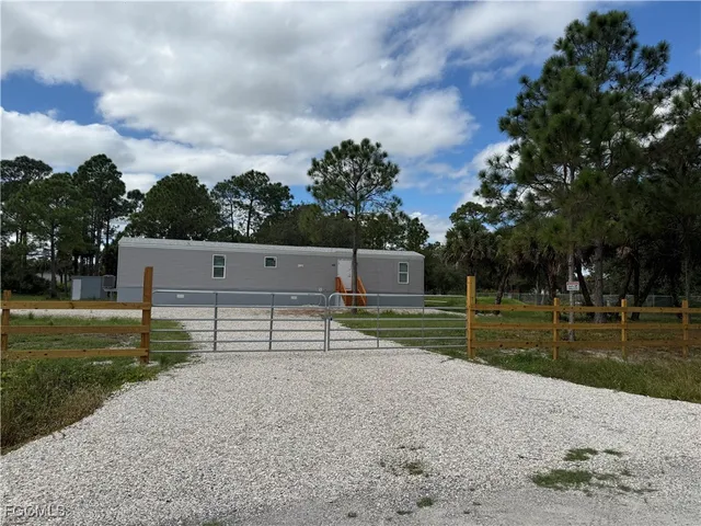 a kitchen with a table chairs a sink dishwasher a stove and a refrigerator with wooden floor