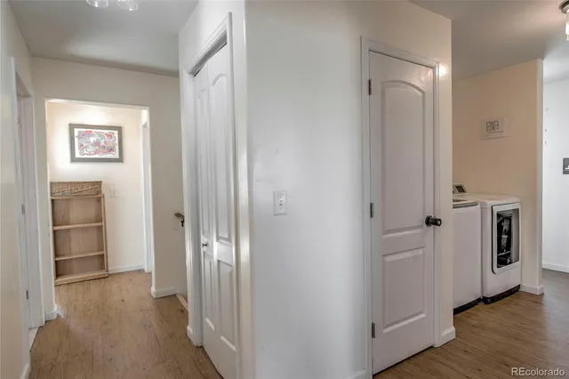 a view of a hallway with bathroom and wooden floor