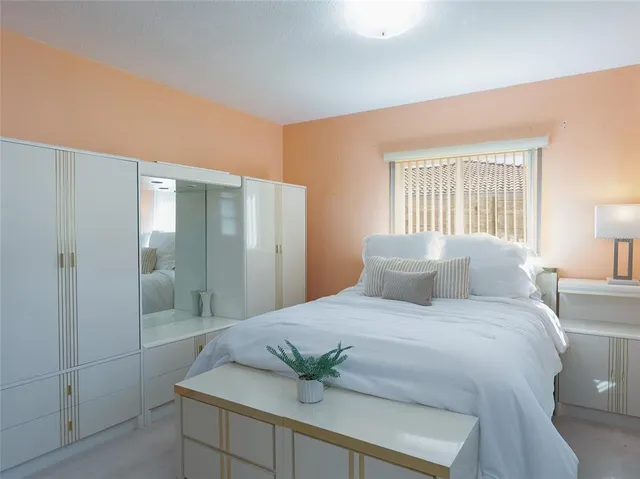 a bedroom with a balcony a bed and a potted plant