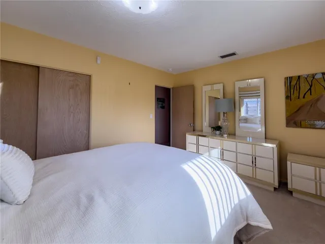 a bed room with a bed and a large mirror