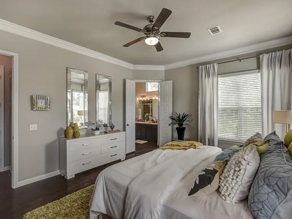 a bedroom with a bed and large windows