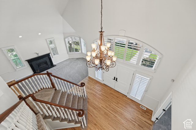 10664 Trail Ridge Circle Sandy, UT 84092 - Photo 25 of 113 Hardwood flooring, wrought iron chandelier, and a curved staircase with carpeted treads