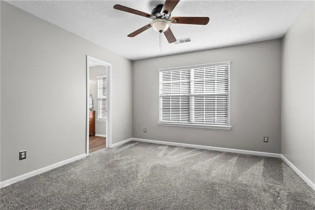 a bathroom with a granite countertop toilet sink and mirror