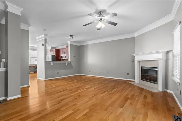 a view of empty room with wooden floor and fireplace