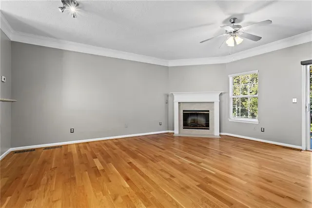 wooden floor fireplace and window in an empty room