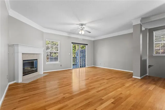 an empty room with windows fireplace and a sink