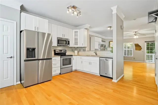 a kitchen with stainless steel appliances a refrigerator sink and cabinets