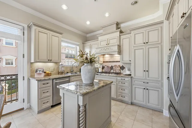 a kitchen with stainless steel appliances granite countertop a stove a sink and a refrigerator