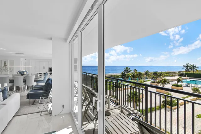 a view of a balcony with chairs and a floor to ceiling window