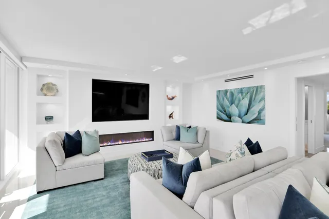 a living room with furniture a flat screen tv and a large window