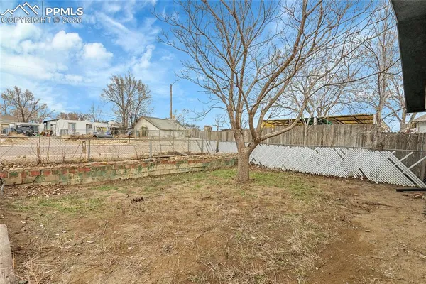 a view of a yard with wooden fence