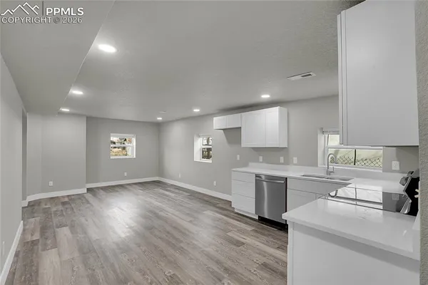 a view of a kitchen with a sink wooden cabinets and stainless steel appliances