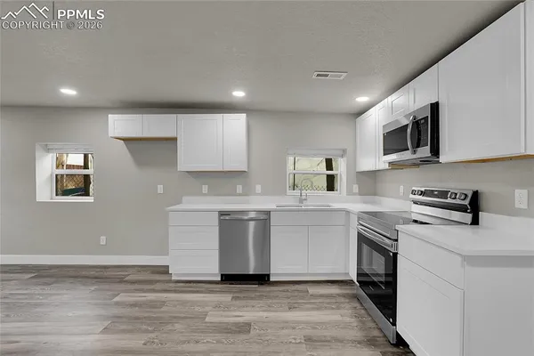 a kitchen with a sink microwave and cabinets