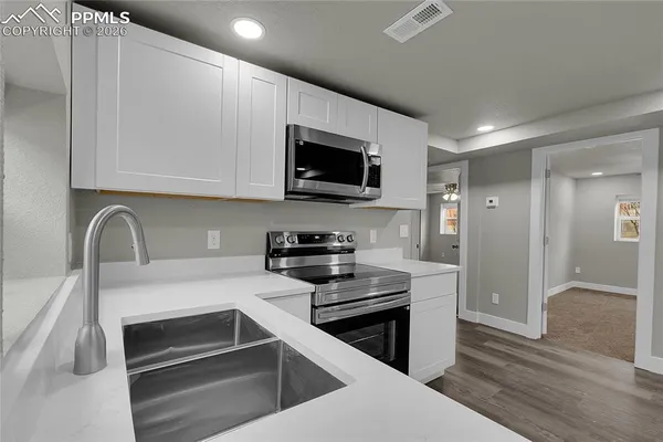 a kitchen with a sink and steel appliances