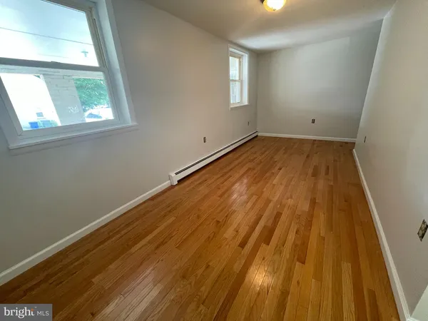 a view of a room with wooden floor and windows