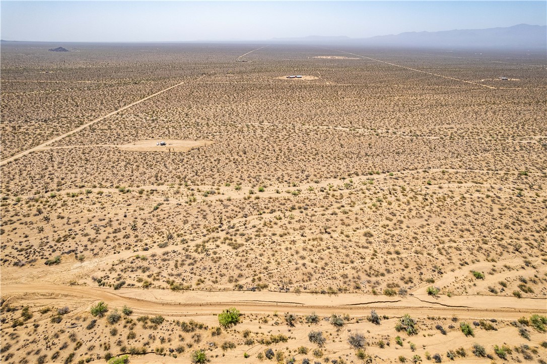 0 East Arroyo Road Yucca, AZ 86438 - Photo 4 of 25 Expansive desert landscape with visible tracks and sparse vegetation