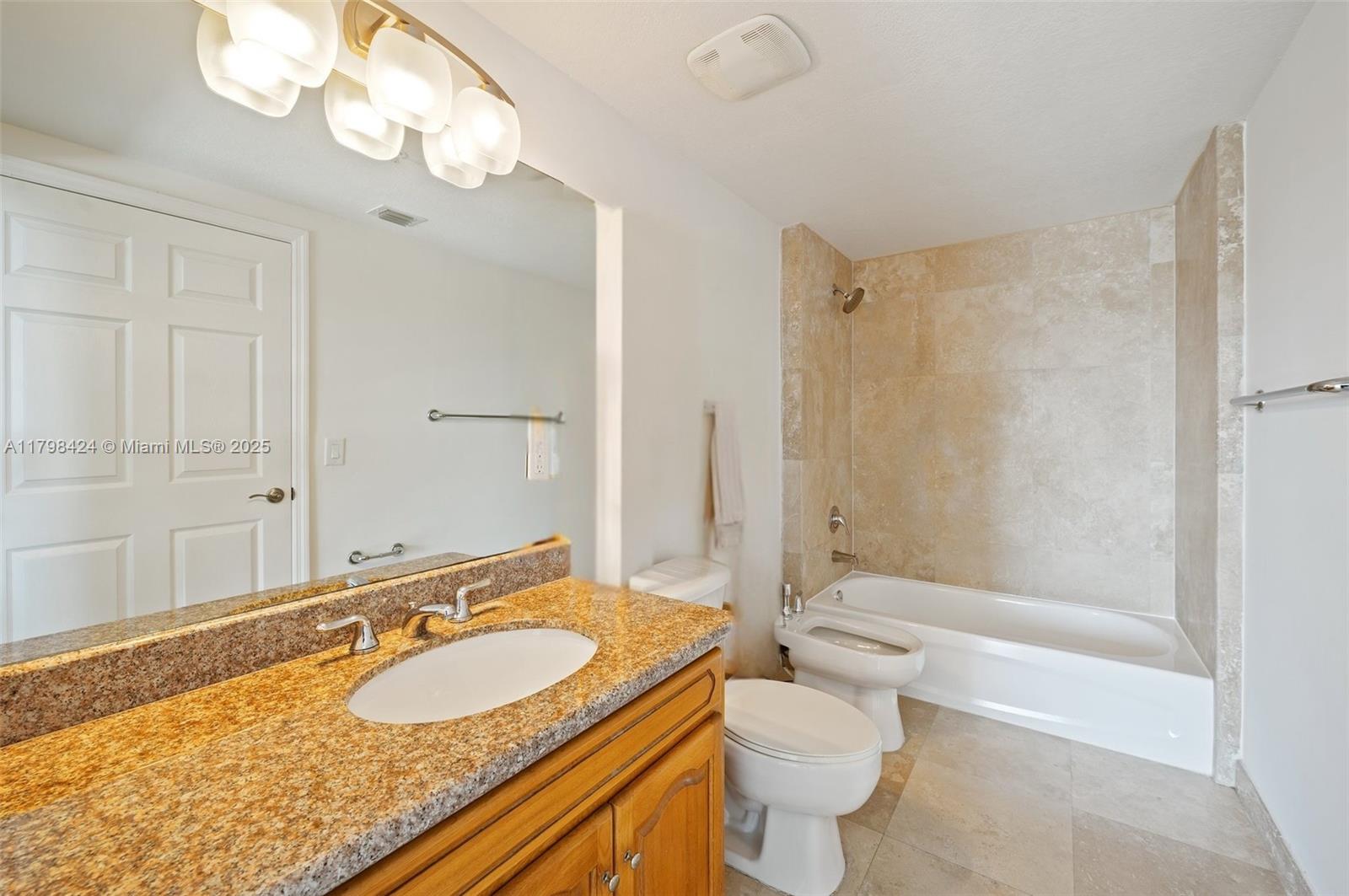 3530 Southwest 22nd Street, Unit 614 Miami, FL 33145 - Photo 13 of 20 a bathroom with a granite countertop sink a toilet a mirror and shower