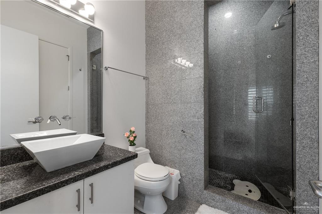 514 Rio Grande Drive Mission, TX 78572 - Photo 17 of 28 a bathroom with a granite countertop sink a toilet and shower