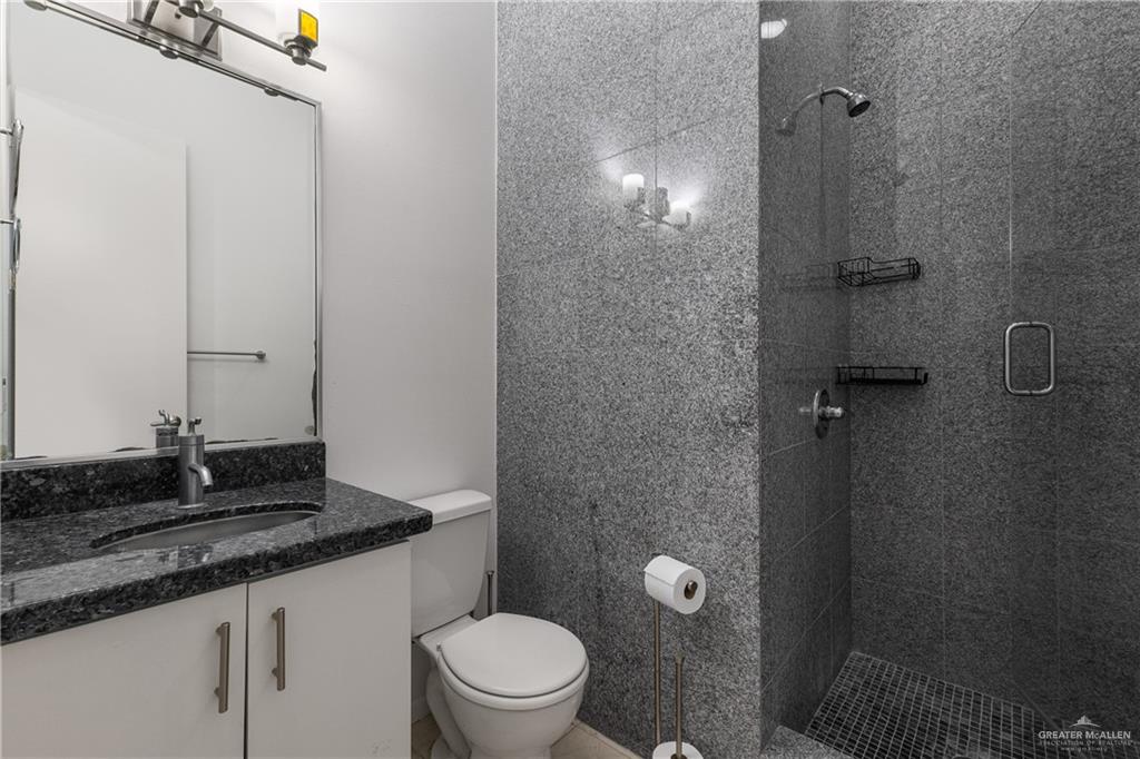 514 Rio Grande Drive Mission, TX 78572 - Photo 22 of 28 a bathroom with a granite countertop sink a toilet and shower