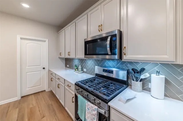 a kitchen with kitchen island granite countertop a sink a stove a microwave and refrigerator