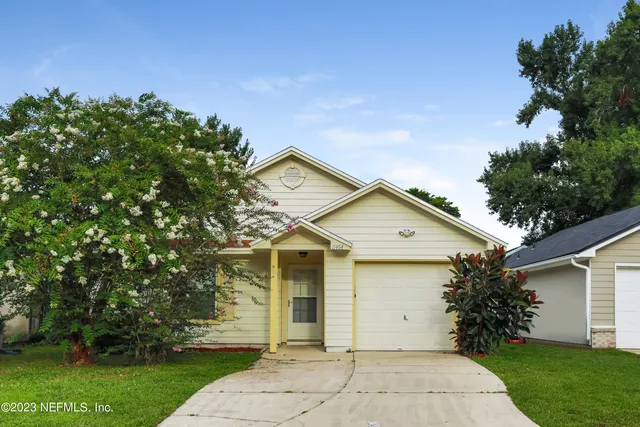 a front view of a house with a yard and trees