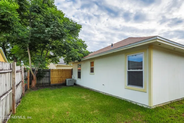 a view of a backyard with potted plants and a large tree