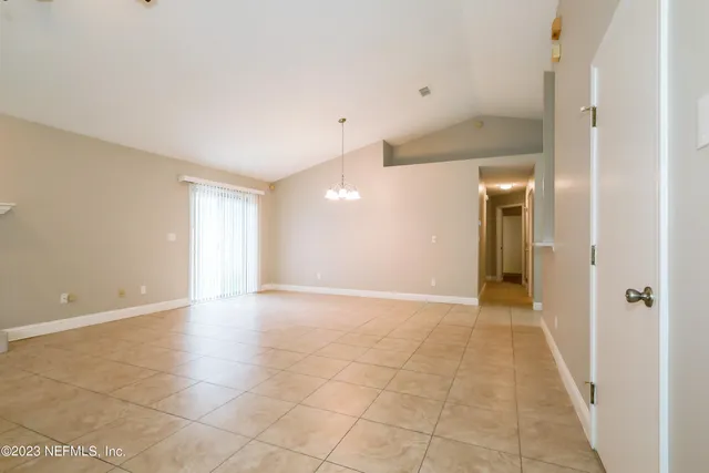 an empty room with windows and fireplace