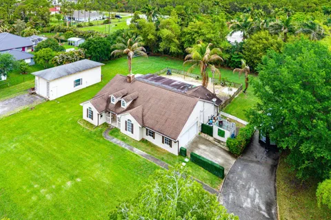an aerial view of residential houses with outdoor space and trees all around