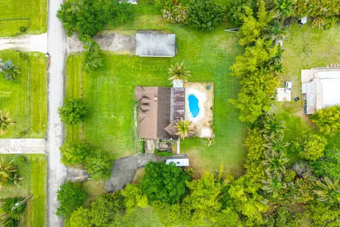 an aerial view of residential houses with outdoor space and swimming pool