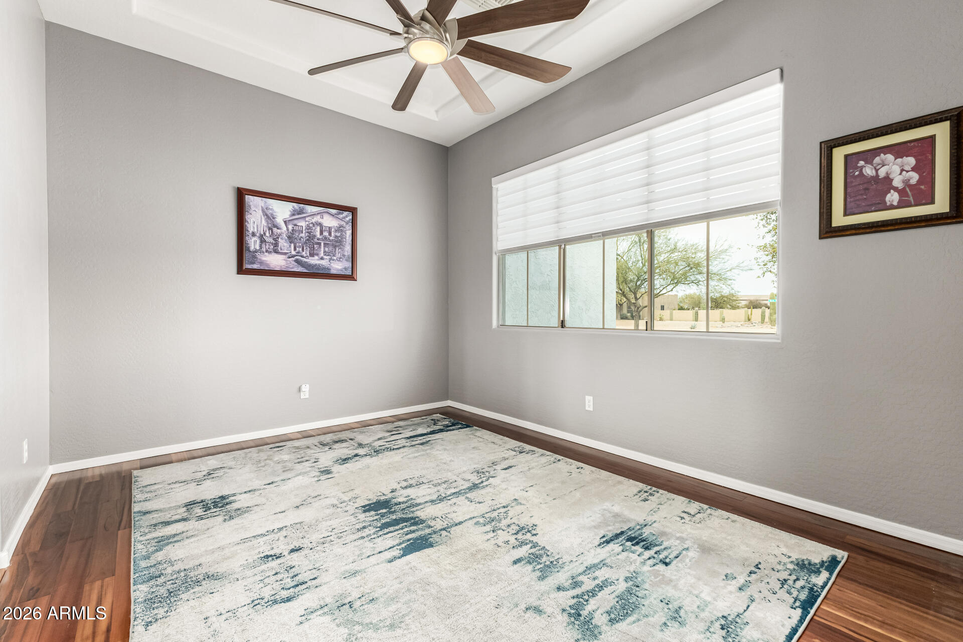 22909 West Sierra Ridge Way Wittmann, AZ 85361 - Photo 39 of 121 a view of a bedroom with wooden floor and window