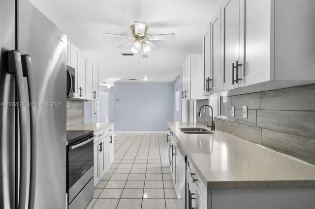 a kitchen with stainless steel appliances granite countertop a sink refrigerator and cabinets