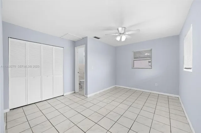 a view of an empty room and chandelier fan