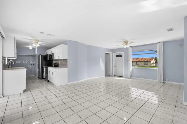 a view of a kitchen with furniture and refrigerator