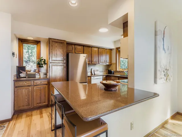 a kitchen with stainless steel appliances a refrigerator a stove a sink and white cabinets