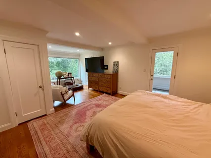 a bedroom with a bed and a flat tv screen on dresser