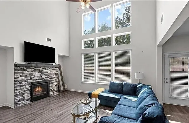 a living room with furniture a flat screen tv and a fireplace