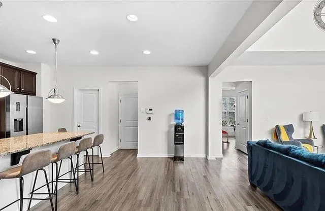 a kitchen with granite countertop kitchen island wooden floors center island and stainless steel appliances