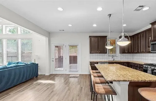 a kitchen with stainless steel appliances granite countertop a stove top oven a sink refrigerator and cabinets