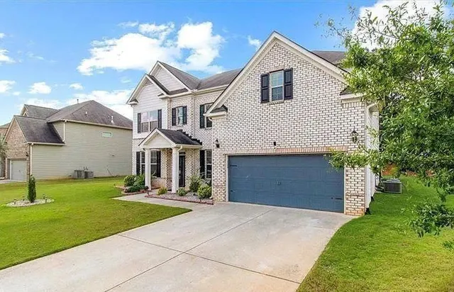 a front view of a house with a yard and garage