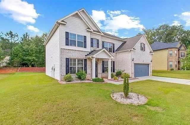 a front view of a house with a yard garage and seating