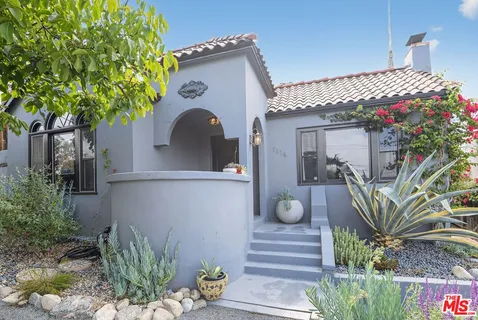 a front view of a house with a garden