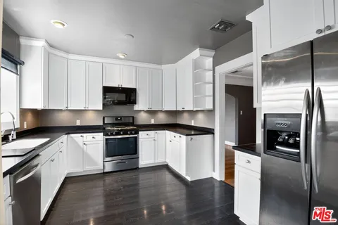 a kitchen with stainless steel appliances and wooden floor